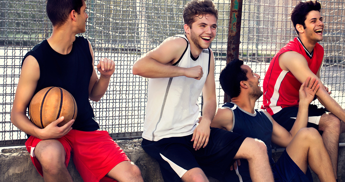 basketball players take a break sitting on a low wall